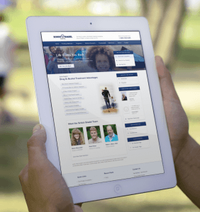 A person holding an iPad looking at the Schick Shadel Hospital custom website that we designed and developed on WordPress
