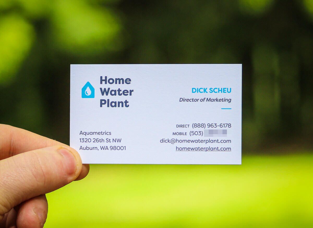 A person holding a business card designed for Home Water Plant by us at Graticle Design