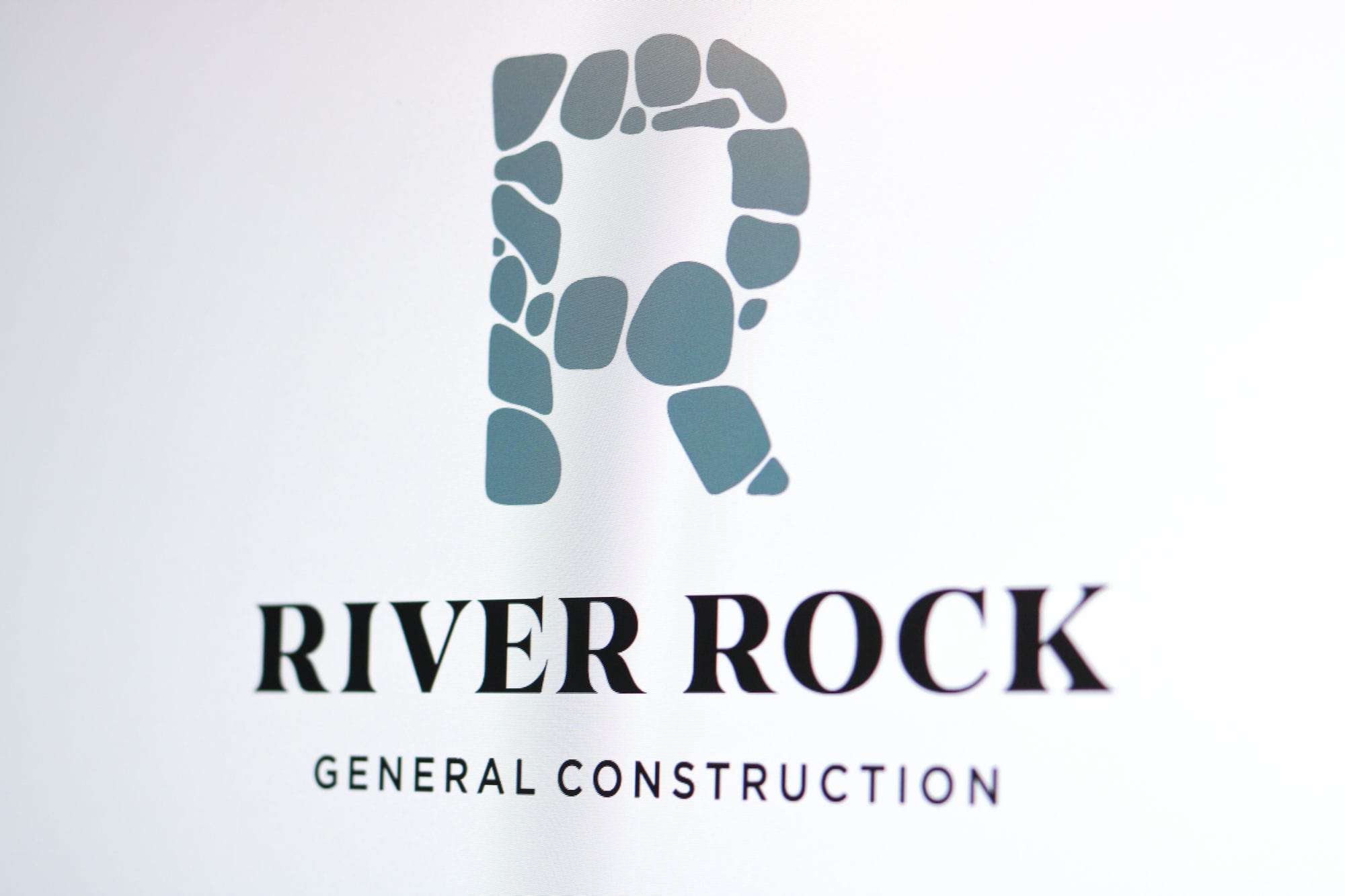 Logo created by Graticle Design for River Rock General Construction, featuring a stylized 'R' composed of river stones.
